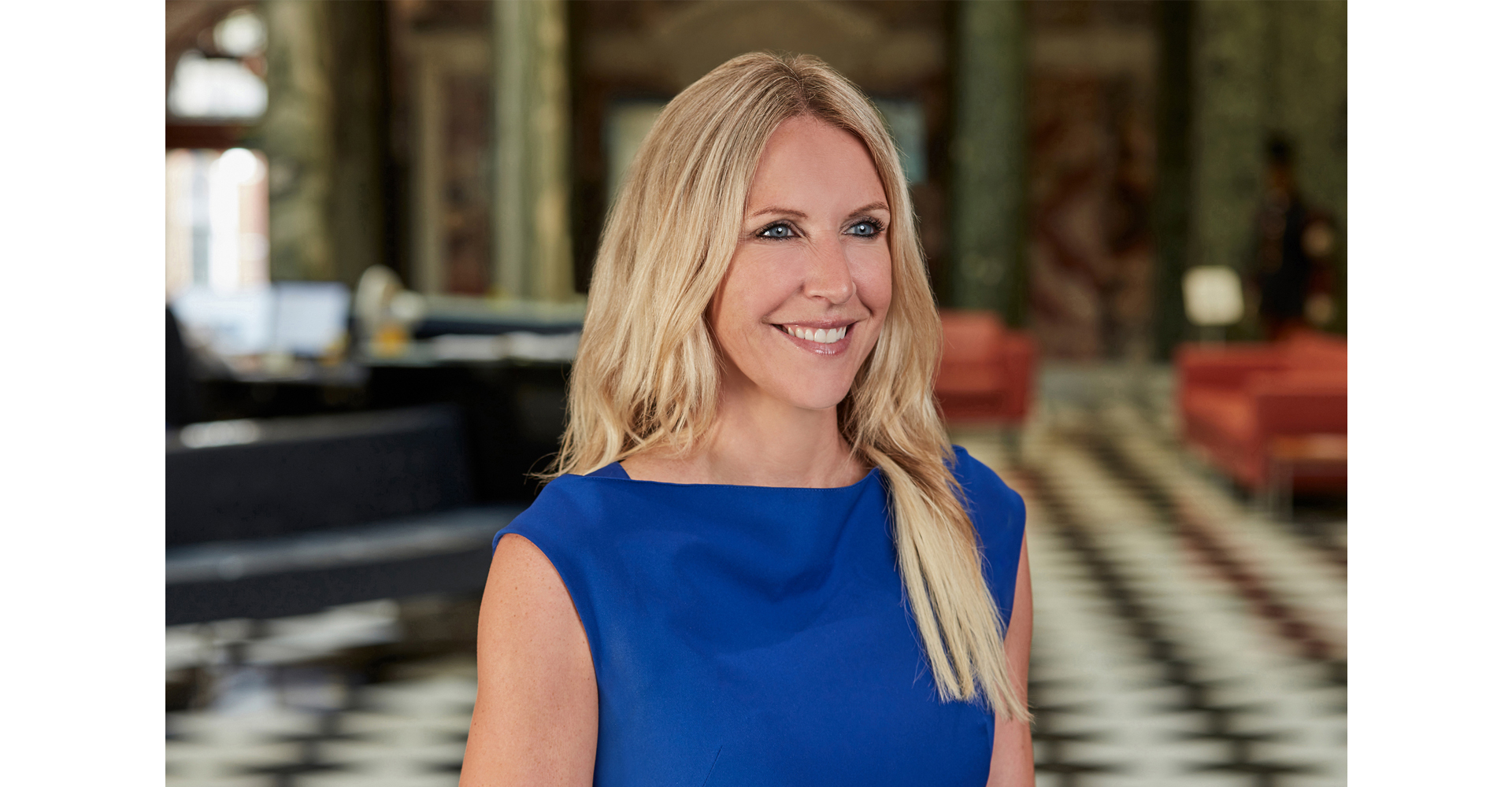 Female business woman posing for corporate head shot in front of Oxford blue backdrop
