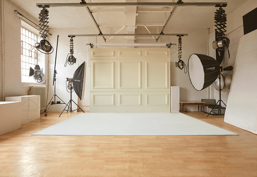 Nic Donovan day light digital photo studio in Norwich showing main photo shoot set up with panel wooden backdrop and wooden and white floor and studio lighting