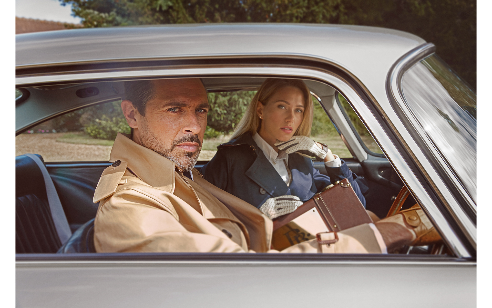 advertising fashion photo shoot for Paul brown clothing male and female model sitting in Aston Martin classic car at egerton house newmarket suffolk