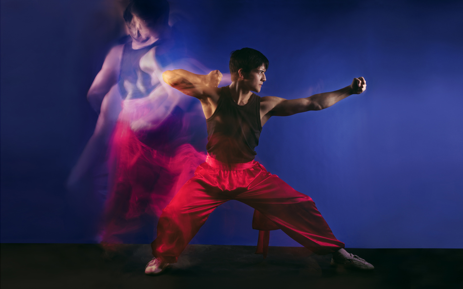 Martial artist performer in a photography studio with motion blur beside him