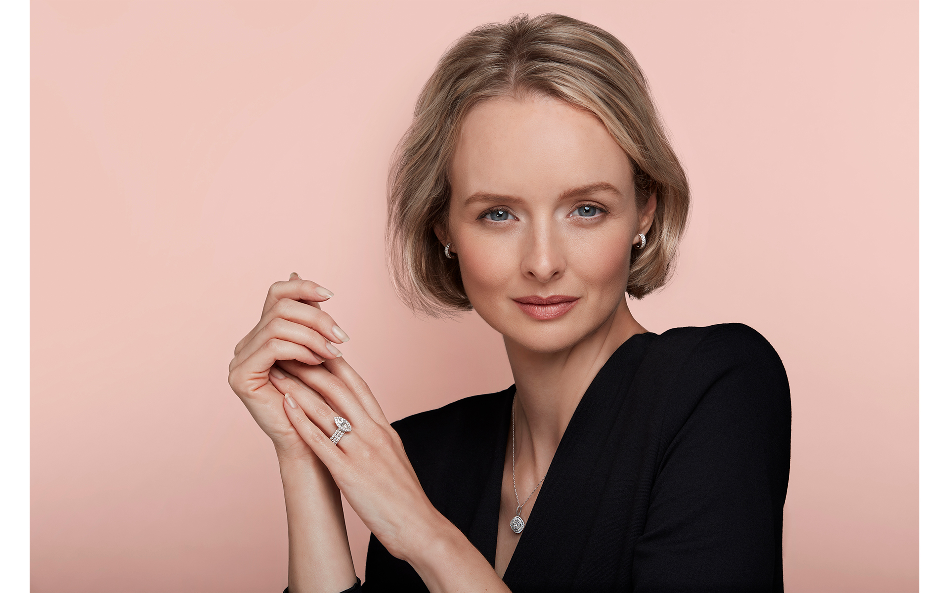 Model in black top wearing jewellery front of a pink back drop for a jewellery advertising photo shoot for winsor bishop
