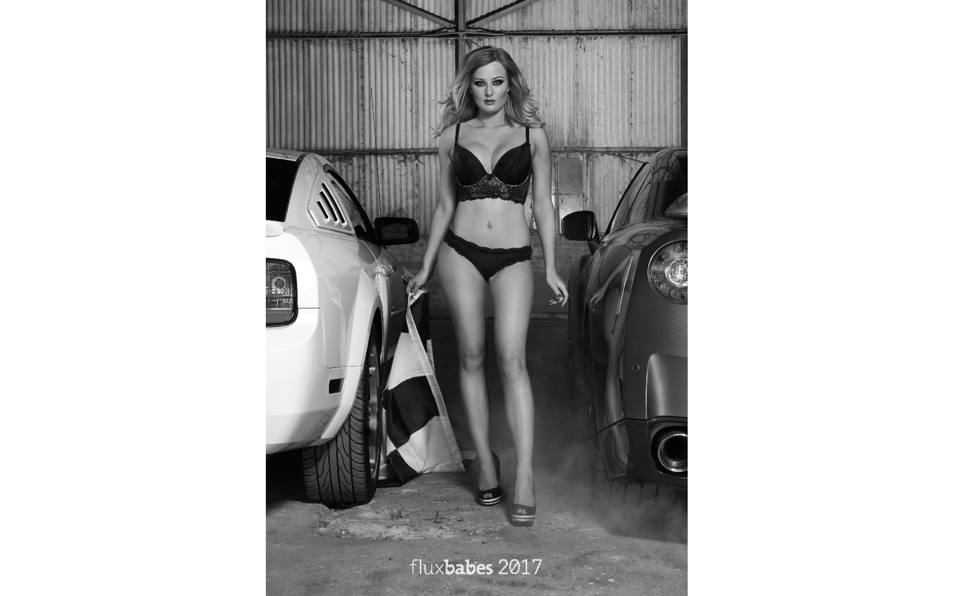 Glamour model in her underwear front of 2 cars in a garage in black and white calendar photo shoots 
