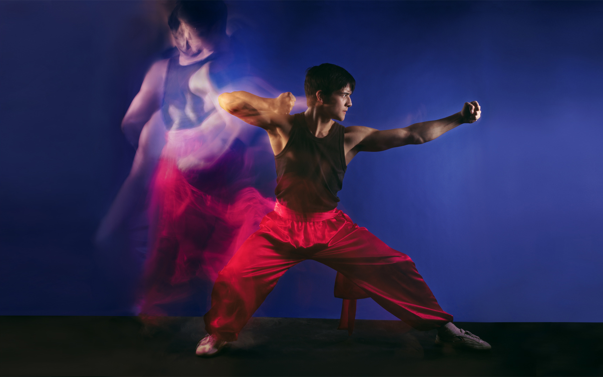 Martial artist performer in a photography studio with motion blur beside him